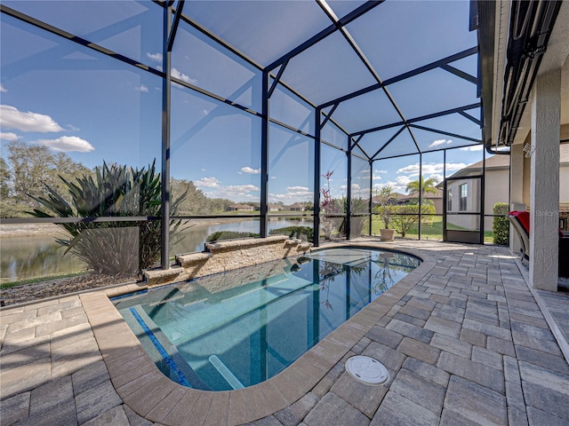 pool featuring glass enclosure, a patio, and a water view