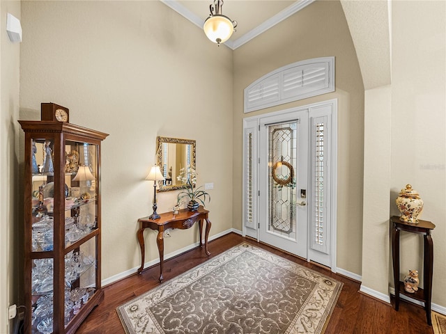 foyer entrance featuring crown molding, baseboards, and wood finished floors