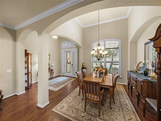 dining space with a notable chandelier, crown molding, baseboards, and wood finished floors