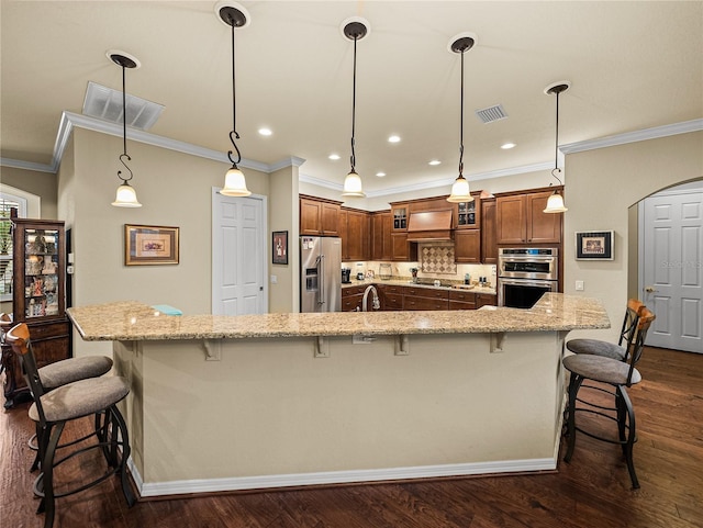 kitchen with visible vents, arched walkways, stainless steel appliances, and a kitchen breakfast bar