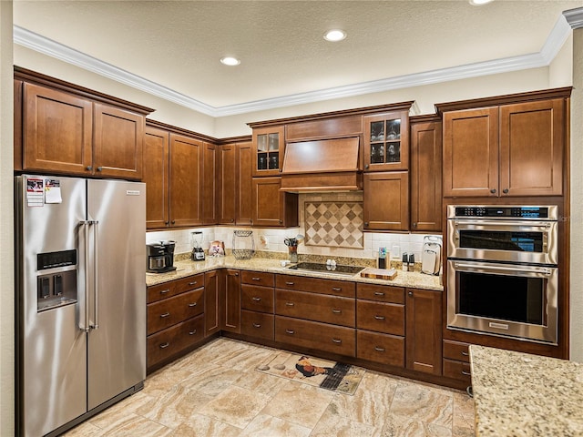 kitchen with glass insert cabinets, light stone counters, stainless steel appliances, and backsplash