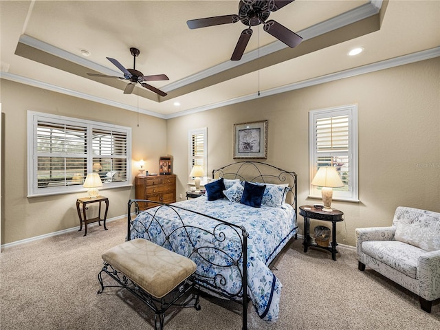 carpeted bedroom with ornamental molding, a raised ceiling, baseboards, and a ceiling fan