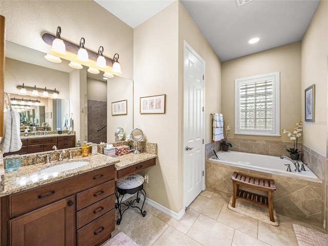 full bathroom featuring a tile shower, vanity, tile patterned flooring, baseboards, and a bath