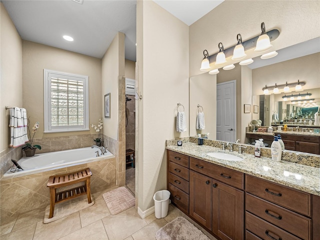 bathroom with walk in shower, tile patterned flooring, a garden tub, and vanity