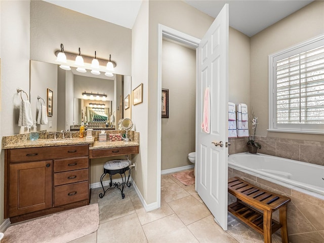 full bath with toilet, vanity, baseboards, a bath, and tile patterned floors