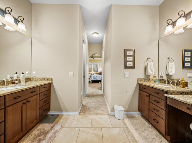 ensuite bathroom featuring ensuite bath, two vanities, a sink, and tile patterned floors