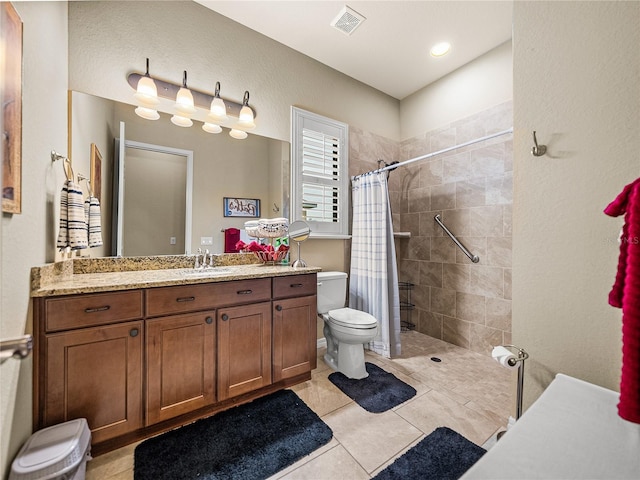 bathroom featuring visible vents, toilet, vanity, tiled shower, and tile patterned floors