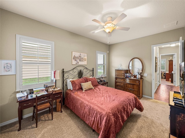 bedroom featuring visible vents, ceiling fan, light carpet, and baseboards