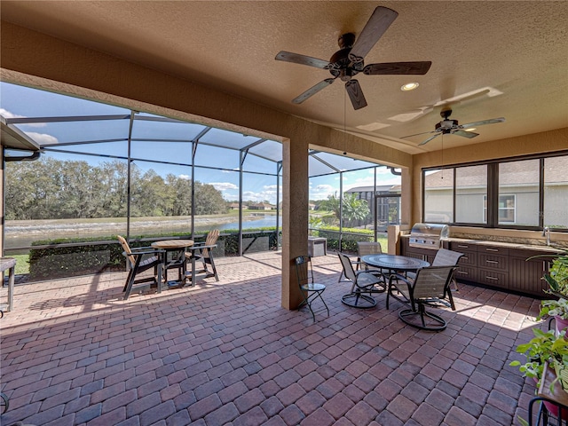 view of patio featuring outdoor dining space, a grill, a sink, ceiling fan, and a lanai