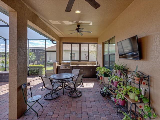 sunroom featuring a sink and a ceiling fan