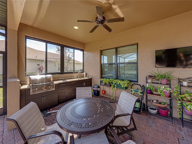 sunroom with a ceiling fan and a sink