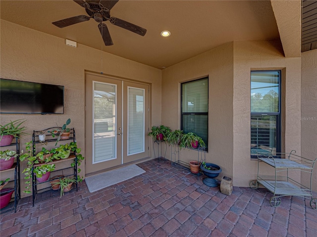 view of exterior entry with a patio, a ceiling fan, and stucco siding