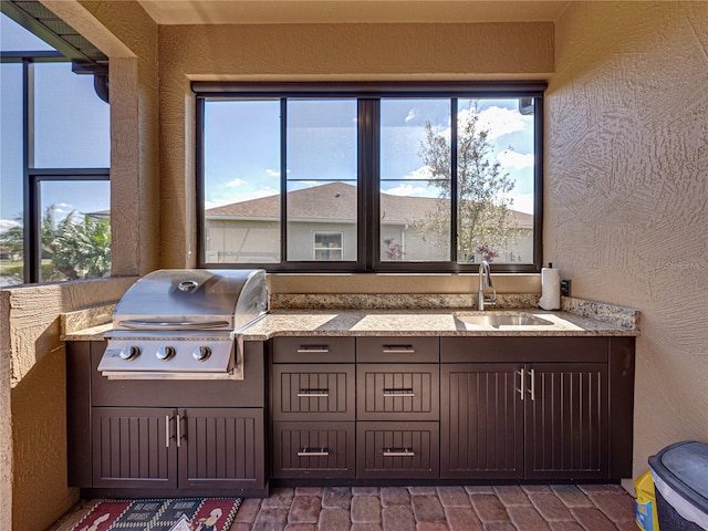 view of patio featuring exterior kitchen, a sink, and grilling area