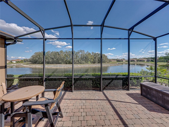 view of patio / terrace with glass enclosure and a water view