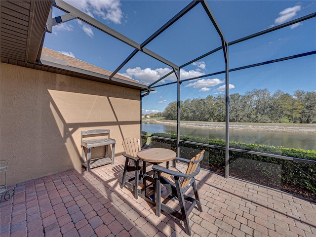 view of patio / terrace with a water view, a lanai, and outdoor dining area