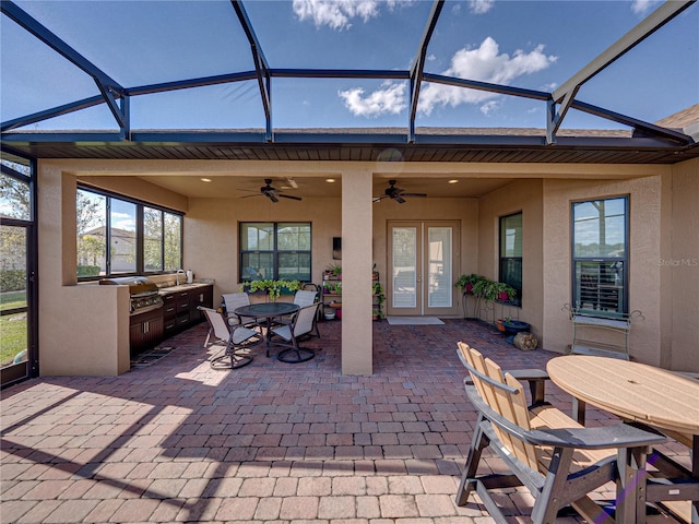 view of patio / terrace with exterior kitchen, outdoor dining area, area for grilling, and a lanai