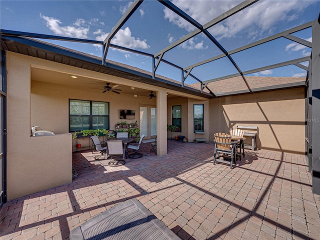 view of patio with outdoor dining area, a lanai, and a ceiling fan