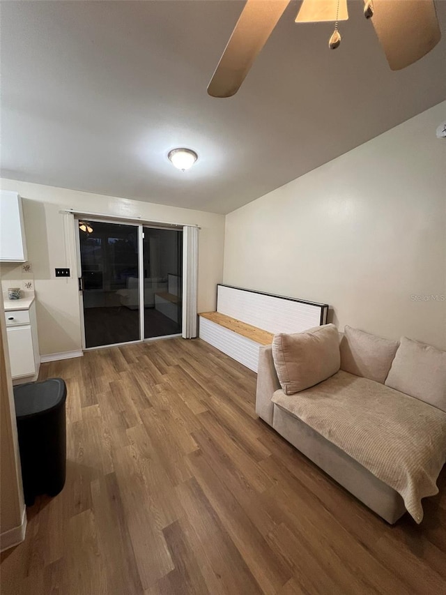 living area with baseboards, washer / clothes dryer, and wood finished floors