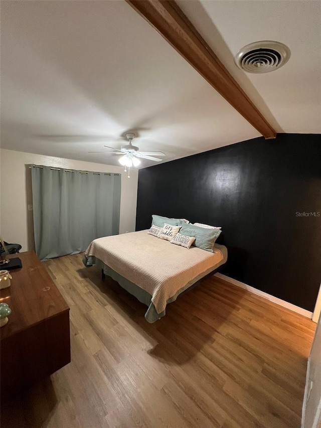 bedroom with baseboards, visible vents, ceiling fan, light wood-type flooring, and beam ceiling