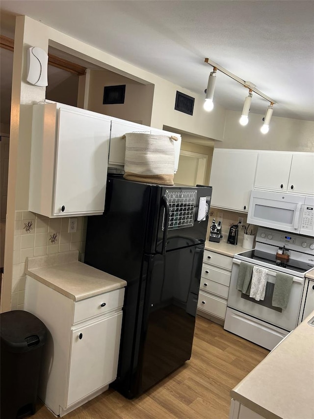 kitchen with white appliances, white cabinetry, light countertops, and backsplash