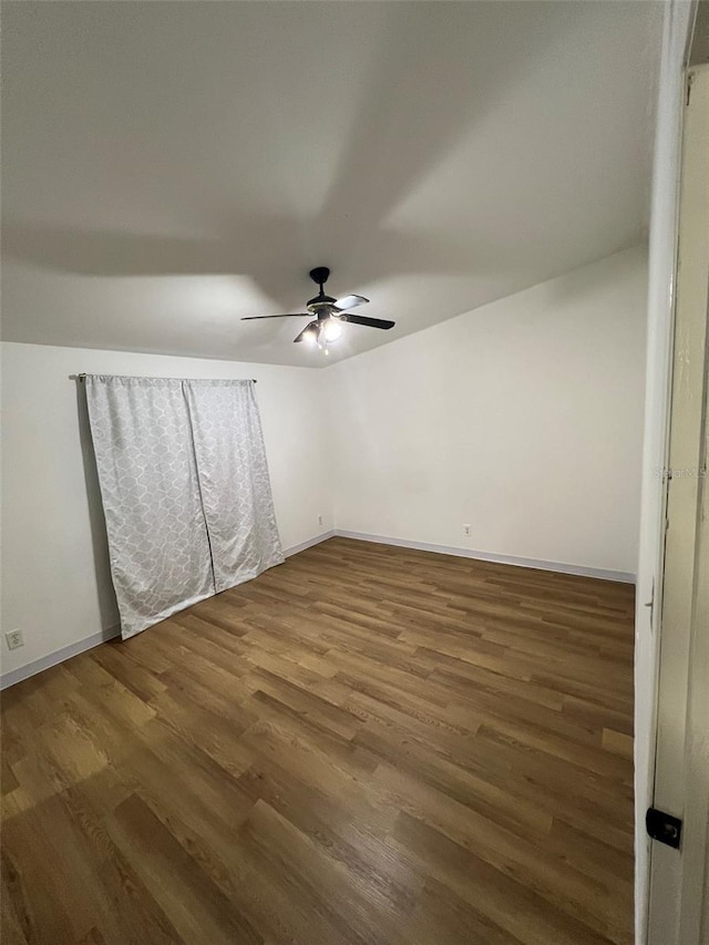 unfurnished room featuring ceiling fan, wood finished floors, and baseboards