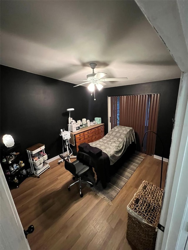 bedroom featuring ceiling fan, wood finished floors, and baseboards