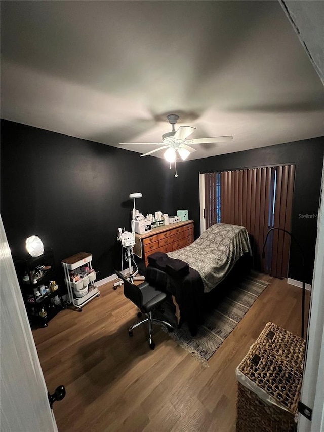 bedroom featuring ceiling fan, wood finished floors, and baseboards