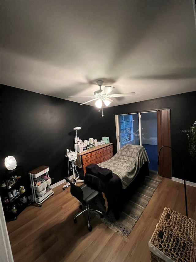 bedroom featuring ceiling fan, wood finished floors, and baseboards