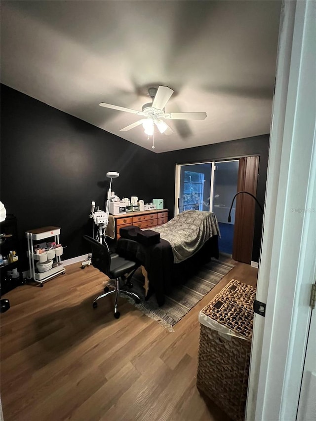 bedroom featuring ceiling fan, wood finished floors, and baseboards