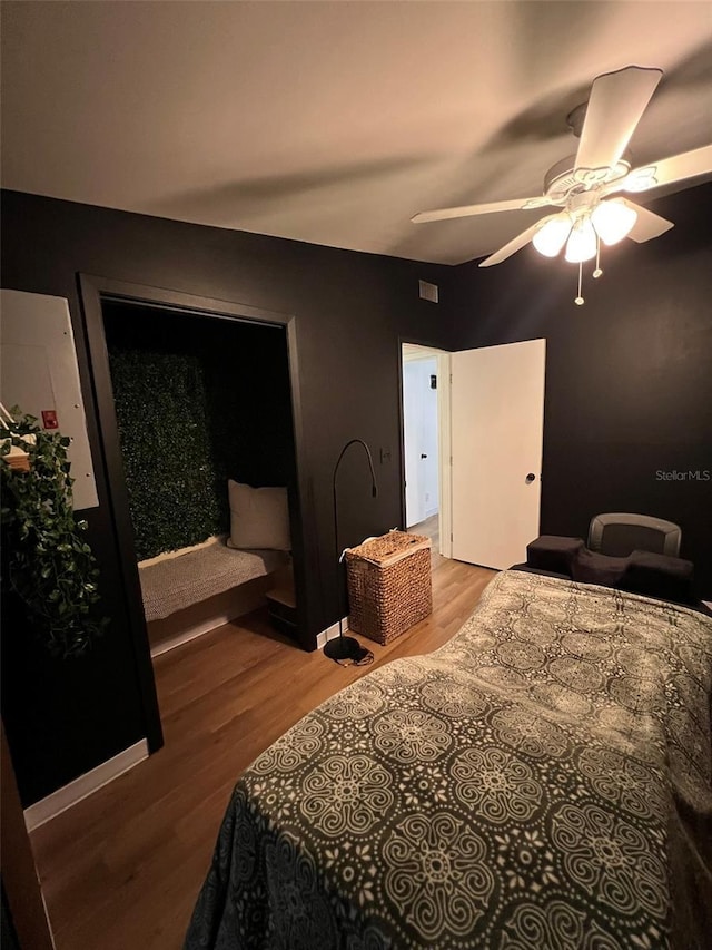 bedroom with light wood-style floors and a ceiling fan