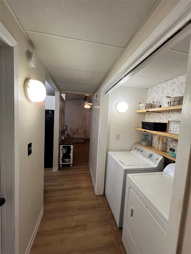 clothes washing area featuring laundry area, independent washer and dryer, wood finished floors, and baseboards