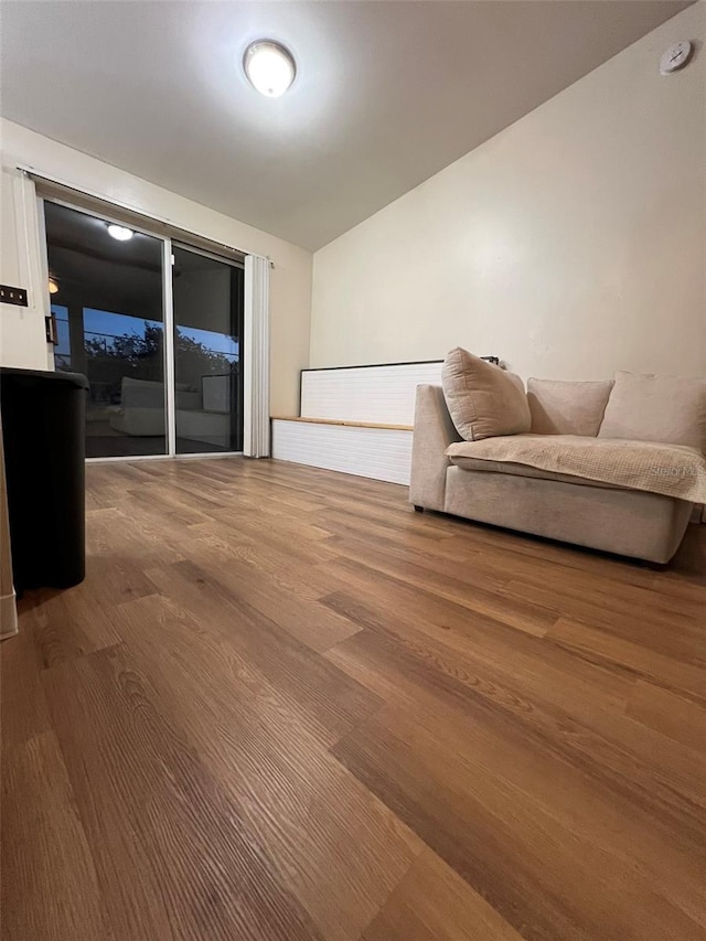 living room featuring vaulted ceiling and wood finished floors