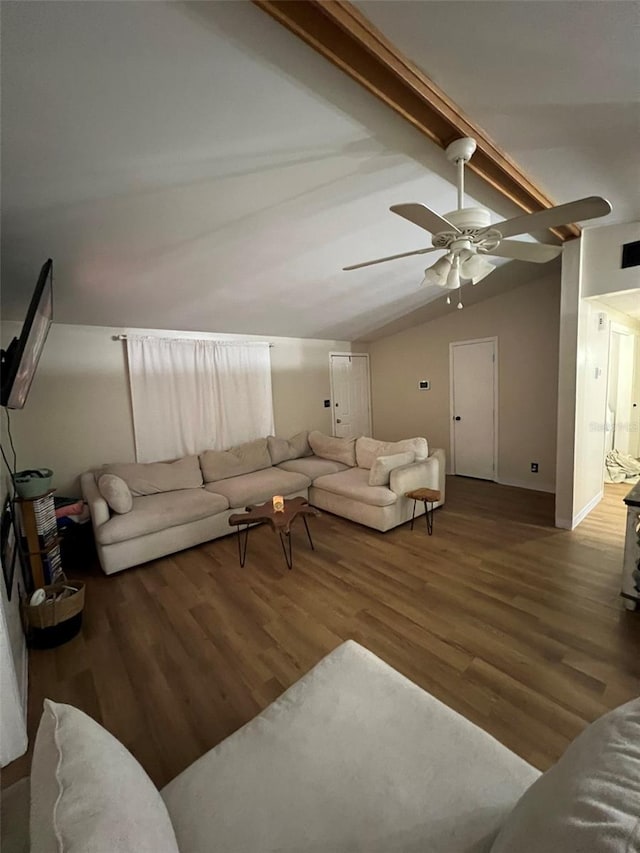 living area with vaulted ceiling with beams, ceiling fan, and dark wood finished floors