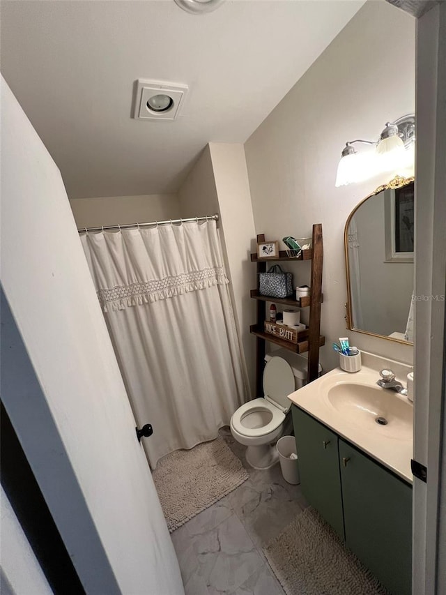 bathroom featuring toilet, marble finish floor, and vanity