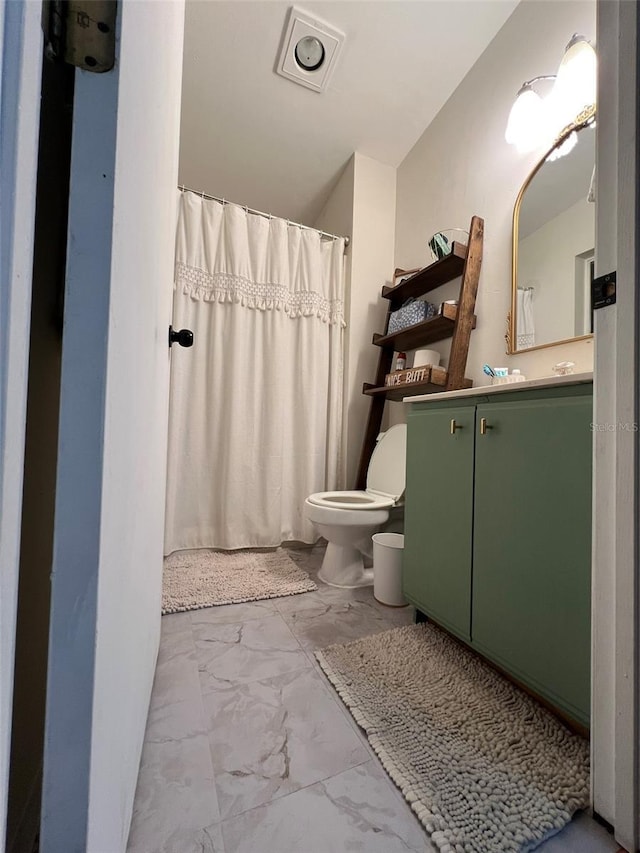 bathroom featuring toilet, marble finish floor, and vanity