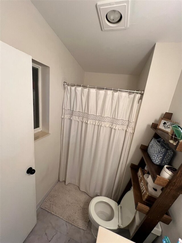 full bathroom featuring marble finish floor, curtained shower, and toilet