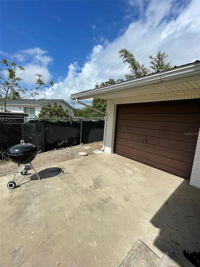 garage featuring fence and driveway