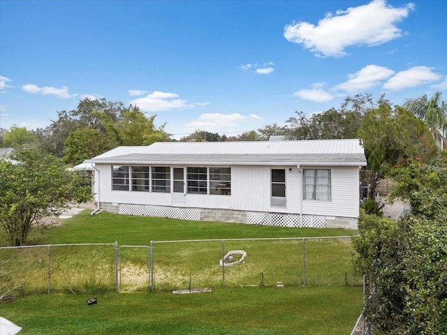 view of front of property with fence private yard, metal roof, and a front lawn