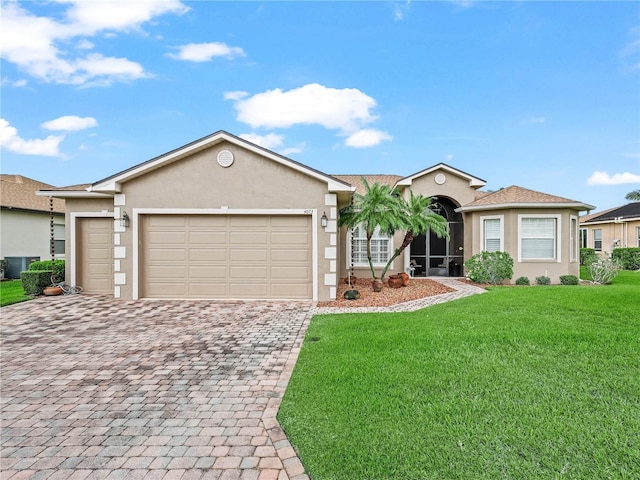 single story home featuring a front lawn, decorative driveway, an attached garage, and stucco siding