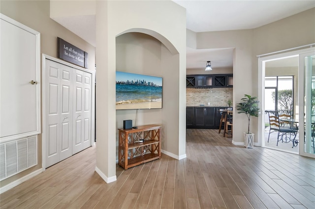 foyer entrance featuring baseboards, visible vents, and light wood-style floors