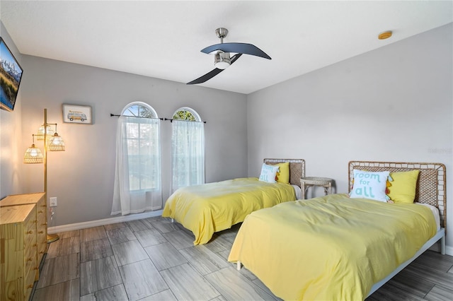 bedroom featuring baseboards, a ceiling fan, and wood finish floors