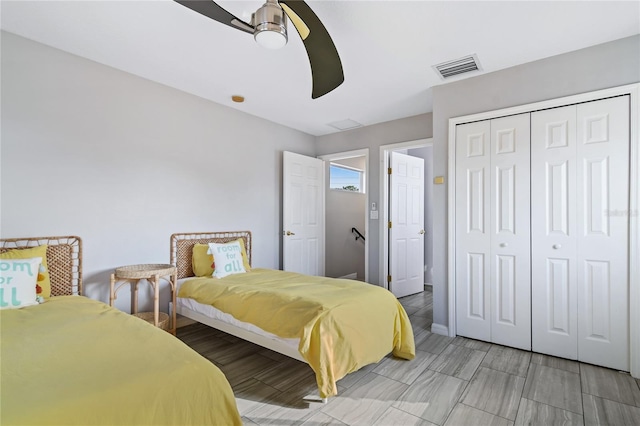 bedroom with baseboards, a closet, visible vents, and a ceiling fan