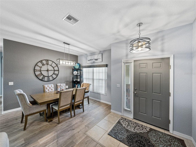 foyer entrance featuring light wood-style floors, visible vents, and baseboards