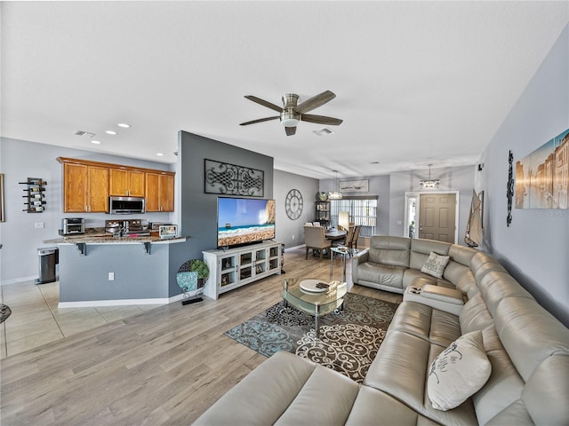 living area featuring light wood-style floors, recessed lighting, visible vents, and baseboards