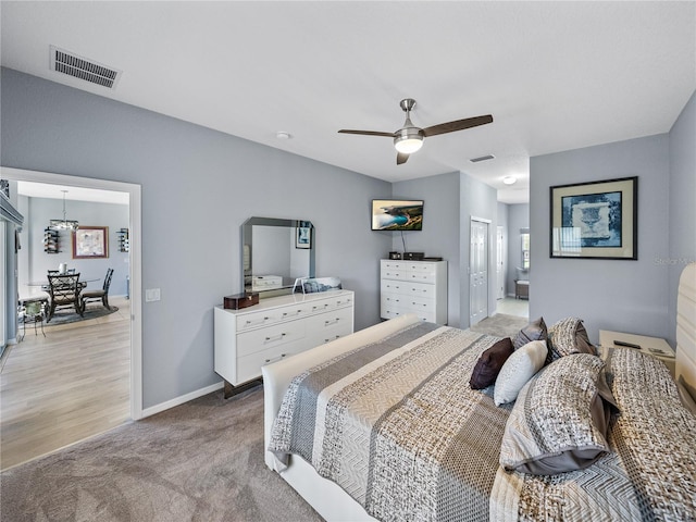 bedroom with ceiling fan, light colored carpet, visible vents, and baseboards