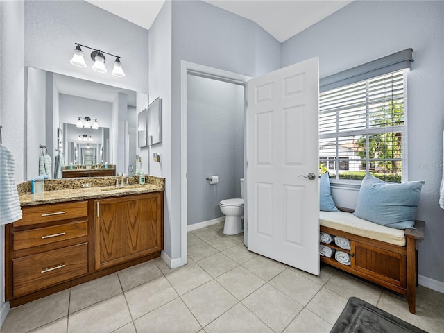 full bathroom with vanity, tile patterned flooring, toilet, and baseboards