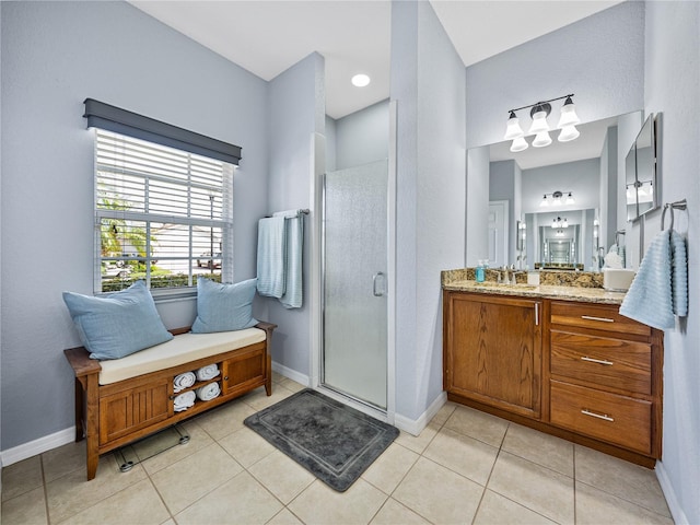 bathroom featuring a stall shower, vanity, and baseboards