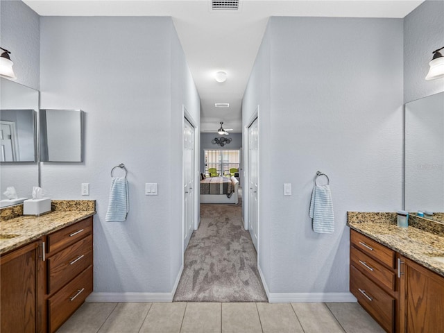 ensuite bathroom featuring visible vents, ensuite bath, vanity, and baseboards