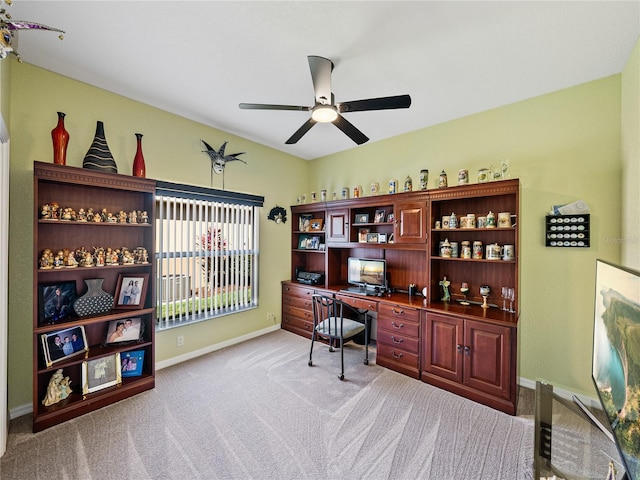 carpeted home office with ceiling fan, built in study area, and baseboards