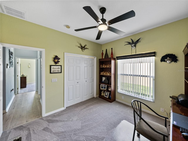 office area featuring a ceiling fan, carpet flooring, visible vents, and baseboards